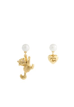 Gold-tone earrings with white pearl studs; one features a hanging cat charm, the other a heart charm with an engraved "C".