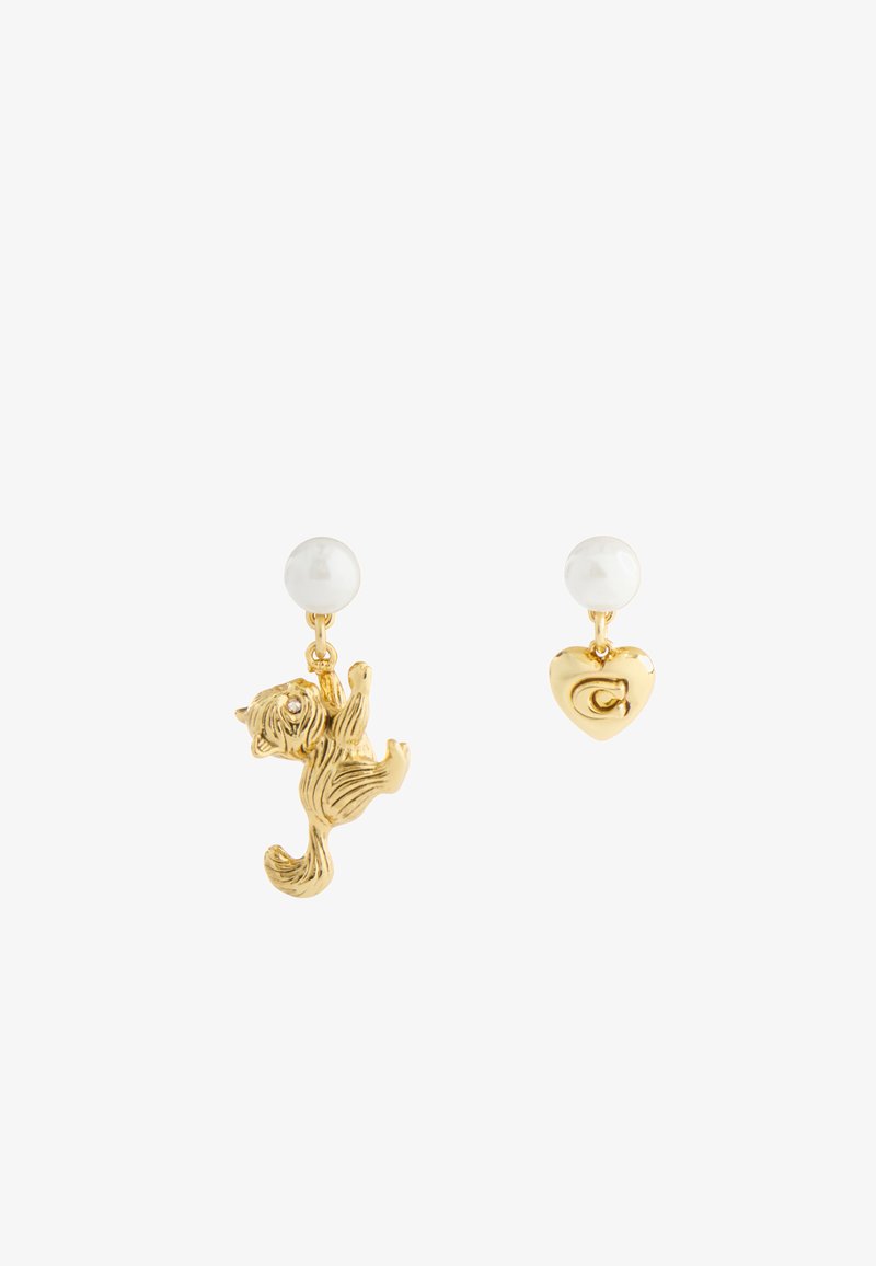 Gouden oorbellen met witte parelstuds; de ene heeft een hangende kattenhanger, de andere een hart hanger met een ingegraveerde "C".