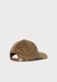 Brun corduroy baseball cap med justerbar rem og metalspænde, vist fra bagsiden på en ensfarvet hvid baggrund.