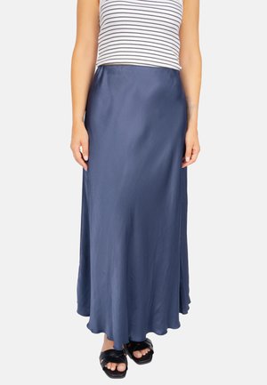 Marineblaue, satinierte Maxirock mit fließendem Schnitt, glatter Textur und subtiler Glanz, kombiniert mit einem gestreiften ärmellosen Oberteil und schwarzen Sandalen.