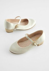 Chaussures Mary Jane en satin crème avec un petit talon, ornées d'une sangle décorative avec un accent en gemme et des semelles intérieure à motif floral.