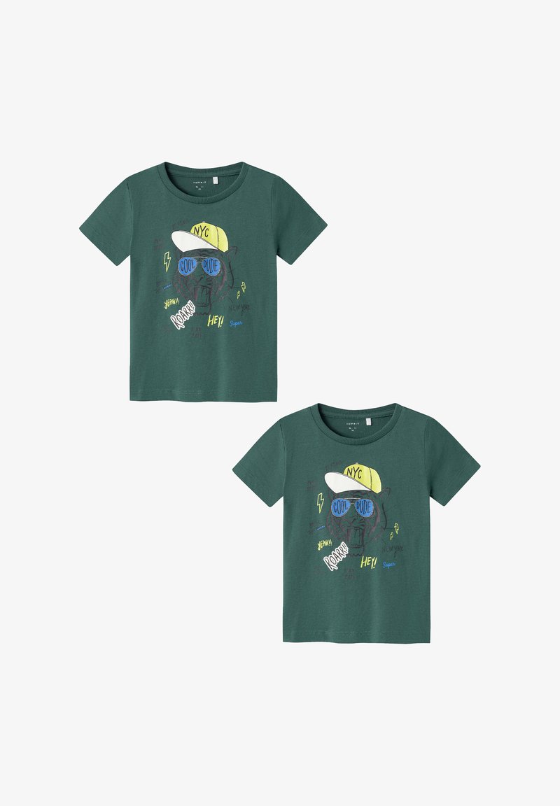 Grünes Baumwoll-T-Shirt mit einem grafischen Motiv eines Bären, der eine Sonnenbrille und eine gelbe Kappe trägt, mit Schriftzug und farbenfrohen Akzenten auf der Vorderseite.