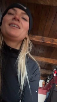 Crna majica s dugim rukavima, visokim vratom i patentnim zatvaračem, nošena s crnom kapom. Drveni strop i razni predmeti vidljivi u pozadini.