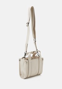 Sac à main beige en cuir lisse avec un design structuré. Il dispose de poignées courtes, d'une bandoulière réglable et d'un compartiment zippé.