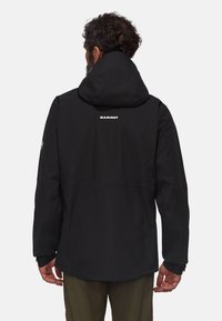 Veste imperméable noire avec capuche, arborant un logo dans le dos, des manches longues et une coupe décontractée. La texture semble lisse.