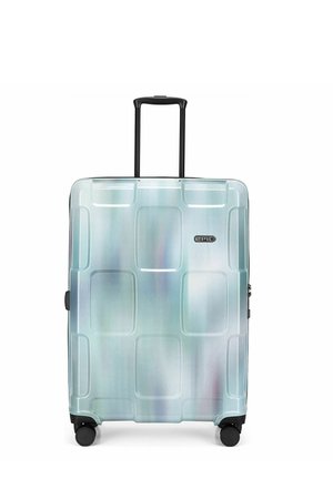 Valise rigide argentée avec quatre roues et une poignée noire allongée, marquée "EPIC" à l'avant.