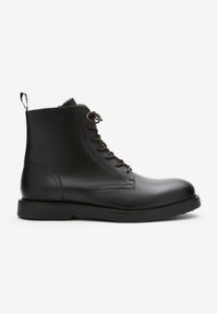 Zwarte leren enkelboots met bruine veters, een afgeronde neus, een vlakke rubberen zool en een lus aan de achterkant voor gemakkelijk aan- en uittrekken.