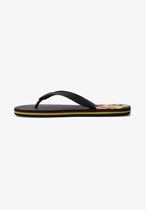 Chanclas negras con una correa texturizada y suela multicolor a rayas en rojo, verde y amarillo. Cuenta con una suela plana.