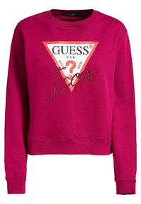 Fuchsia sweatshirt met lange mouwen, geribbelde manchetten en zoom. Kenmerkt zich door een witte driehoekige grafische afbeelding met rode rand en "Icon" versierd met steentjes.