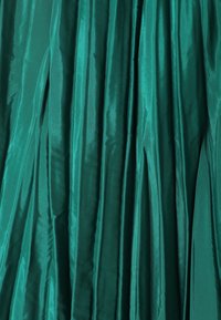 Tejido plisado en tono verde azulado con una textura suave, similar a la del satén, que exhibe profundos pliegues verticales y un color rico y vibrante.