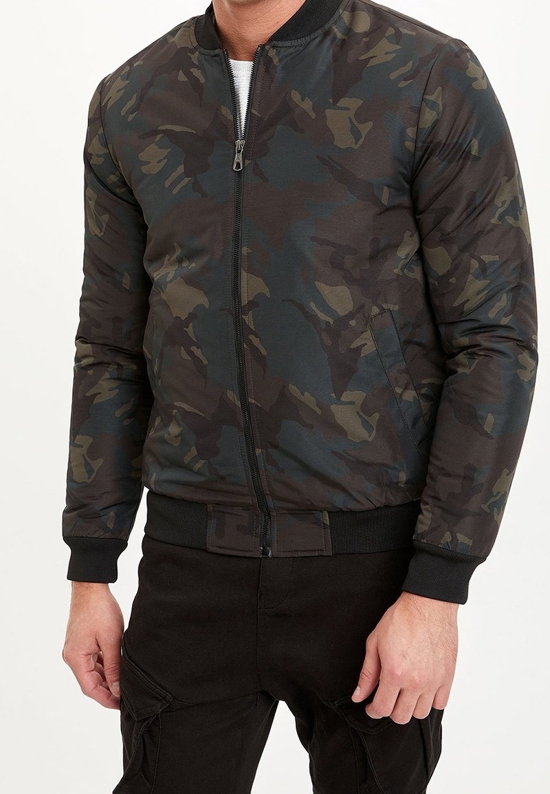 Giubbotto bomber mimetico in tonalità verde scuro, nero e marrone, con chiusura a zip, collo e polsini a costine e tasche laterali.