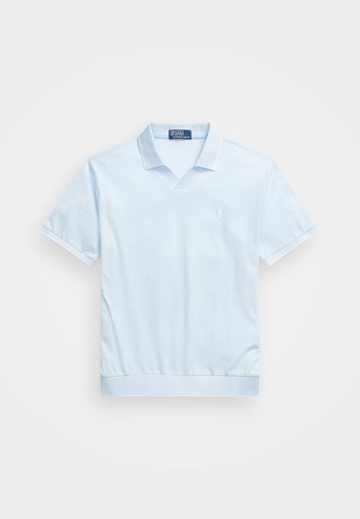 Svetlo modra polo majica s kratkimi rokavi, ovratnikom v obliki črke V in rebrastimi manšetami. Ima diskreten logotip na prsih in raven rob.