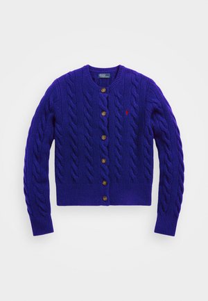 Lila gestrickte Strickjacke mit einem Zopfmuster, rundem Ausschnitt und Knopfverschluss. Sie hat fünf braune Knöpfe und ein kleines Logo auf der Brust.