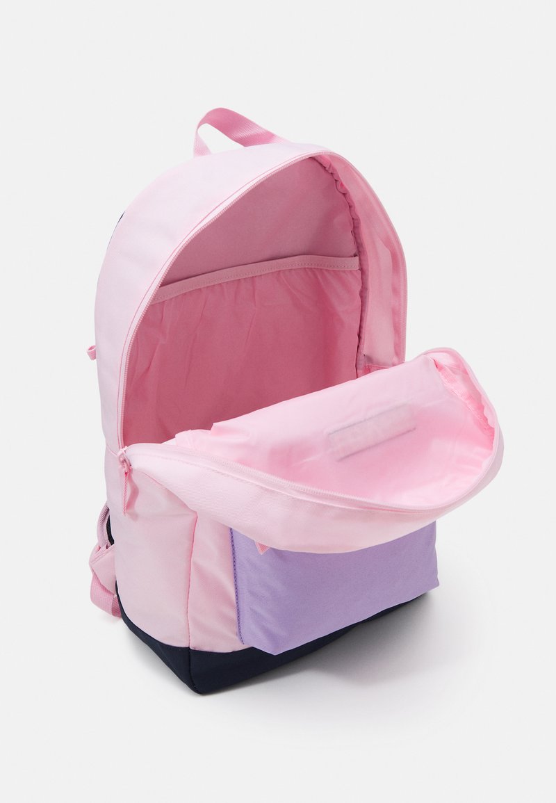 Sac à dos en tissu rose avec une poche avant violette, fermeture zippée et intérieur spacieux doublé de matériau rose assorti.
