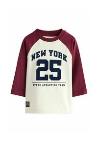 Balta garām piedurknēm T-kreks ar bordo raglanu piedurknēm, kurā redzami uzraksti tumši z blue krāsā "NEW YORK 25" un "STATE ATHLETICS TEAM."