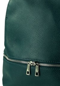Teal leren rugzak met een gestructureerd oppervlak, metalen rits hardware en een strak ontwerp met een voorzak met rits.