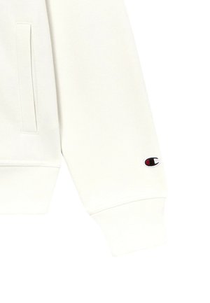 Bílá mikina s kapucí vyrobená z kombinace bavlny a polyesteru. Má žebrované manžety a malou nášivku s logem na rukávu. Hladká textura.