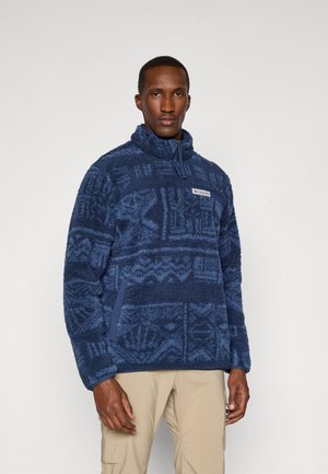 Sudadera de forro polar en azul oscuro con un patrón geométrico, cuello alto y media cremallera, con bolsillos laterales y un parche con el logo en el pecho.