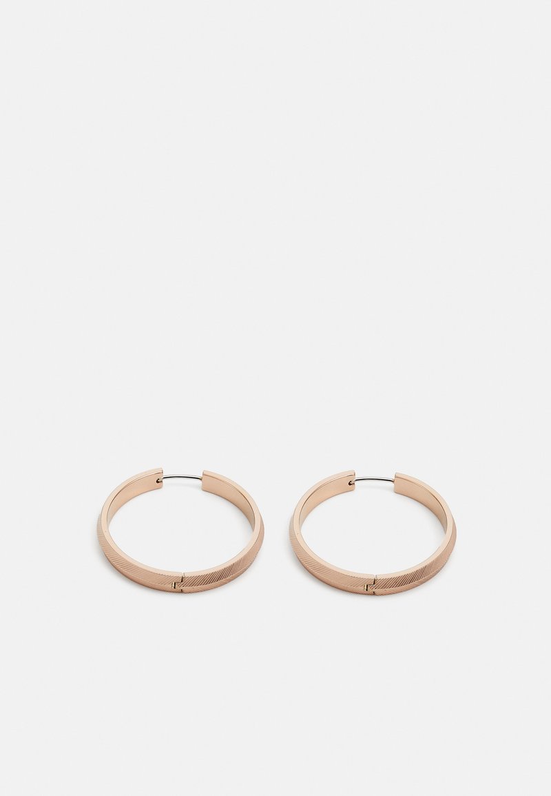 Náušnice ve tvaru kruhu z růžového zlata s matným povrchem, které mají hladký povrch a jemný texturovaný akcent podél okraje.