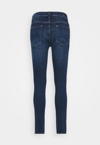 Tajta jeans i mörkblå denim, med midjehöjd, fem fickor och subtila sömnadsdetaljer på baksidan.