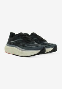 Scarpe atletiche con una tomaia in rete nera traspirante, accenti grigi, una suola intermedia bianca ammortizzata e una suola esterna in gomma nera a motivo.