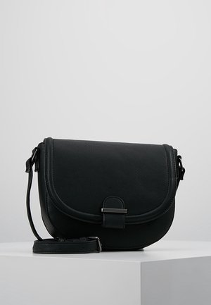 Sort læder crossbody taske med klaplukning og metalspænde, justerbar rem, placeret på en hvid pedestal mod en grå baggrund.