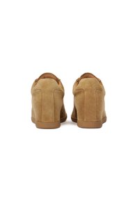 Scarpe con tacco a cuneo in suede color nocciola con una finitura liscia. Presentano un design a bassa apertura, un pratico passante sul retro e suole in gomma. Dettagli delle cuciture delicati.