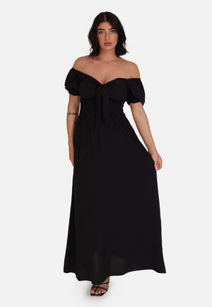 Sort off-the-shoulder maxi kjole lavet af let stof, med puffede ærmer, smocket liv og front binding detaljer.