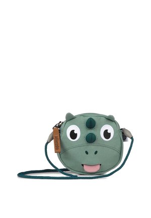 Grüne kindgerechte Umhängetasche in Form eines lächelnden Dinosauriergesichts mit zwei Hörnern, großen Augen und einer herausgestreckten Zunge.