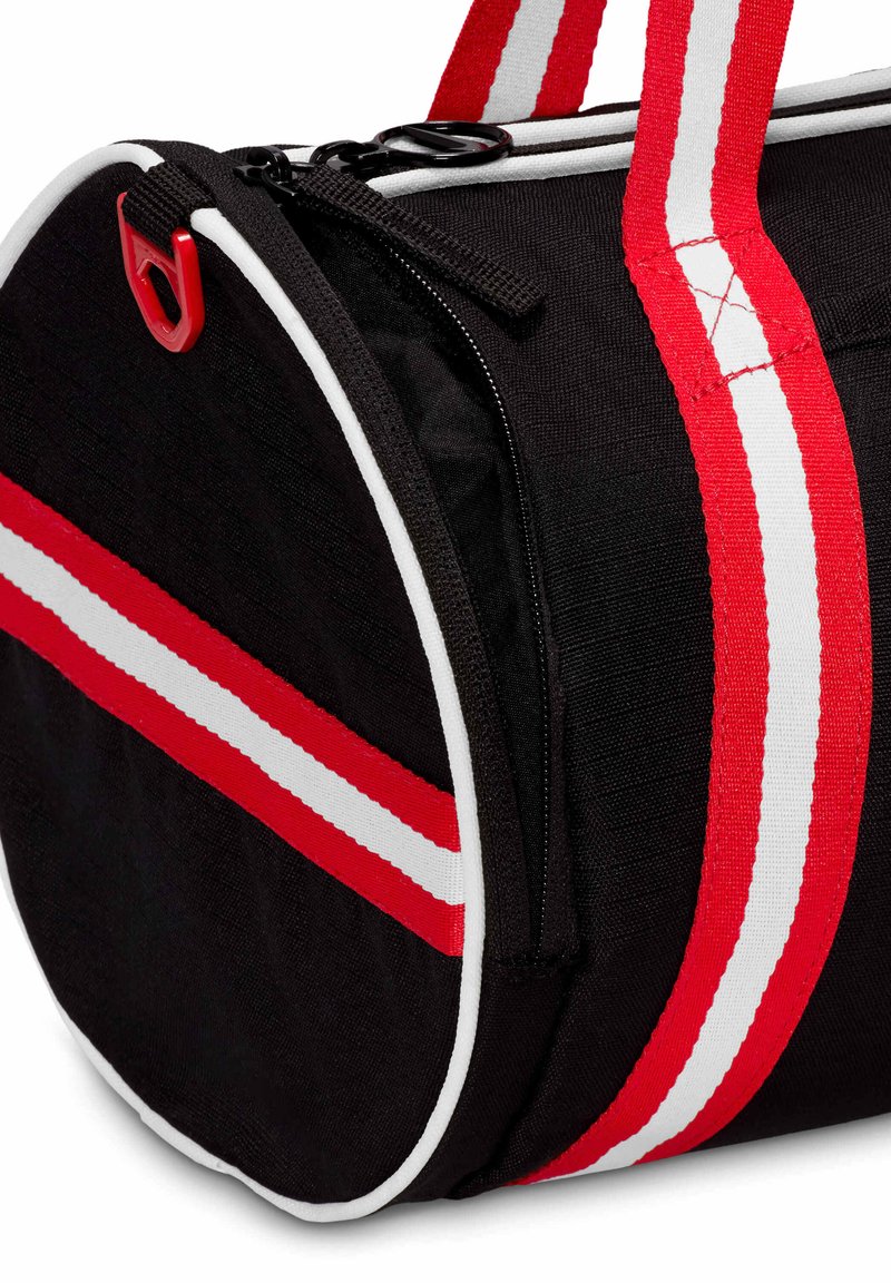 Borsa da palestra rotonda nera con strisce rosse e bianche, manico rifinito in rosso, cerniera nera e un gancio in plastica rossa sul lato.
