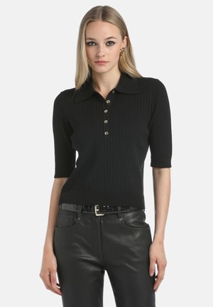 Zwarte geribbelde polo met korte mouwen, met een puntige kraag en vijf gouden knopen. Draag het met zwarte leren broek met hoge taille.