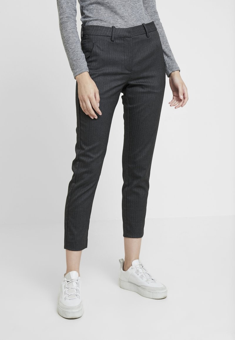Grijs gestreepte broek met een slim fit, een medium taille en zijzakken, gecombineerd met witte sneakers. Gladde textuur en op maat ontworpen.