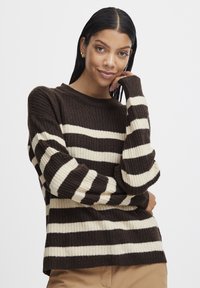 Maglione a righe marroni e crema con texture a coste e scollo rotondo. Caratterizzato da maniche lunghe e una vestibilità ampia.