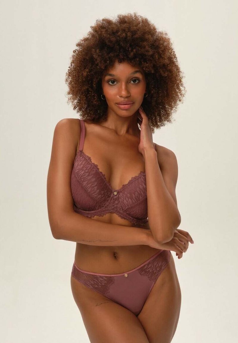 Fioletowy koronkowy stanik z kwiatowymi wzorami i regulowanymi ramiączkami, w zestawie z pasującym stringami. Obydwa elementy zdobione delikatnymi złotymi detalami.