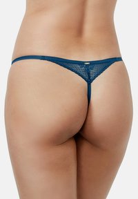 String en dentelle bleu marine avec de fines bretelles et une ceinture texturée, présentant une section en dentelle transparente à l'arrière pour un design délicat.