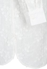 Weißes Hemd mit floralem Stickerei, featuring eine strukturierte Oberfläche, abgerundetem Saum und Knopfmanschetten. Schlichtes und elegantes Design.