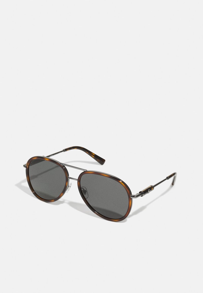 Ochelari de soare cu cadru de țestoasă, cu lentile gri, formă ovală, accente din metal și brațe subțiri, având un design cu cadru în două tonuri și suporturi pentru nas ajustabile.