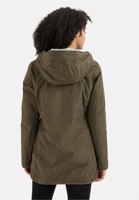 Veste à capuche vert olive avec une coque lisse et résistante à l'eau et une doublure en polaire. Caractérisée par une coupe mi-longue et une capuche à cordon ajustable.