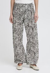 Pantalons légers et amples avec un motif abstrait noir et blanc. Ils présentent une taille élastique et une texture lisse.