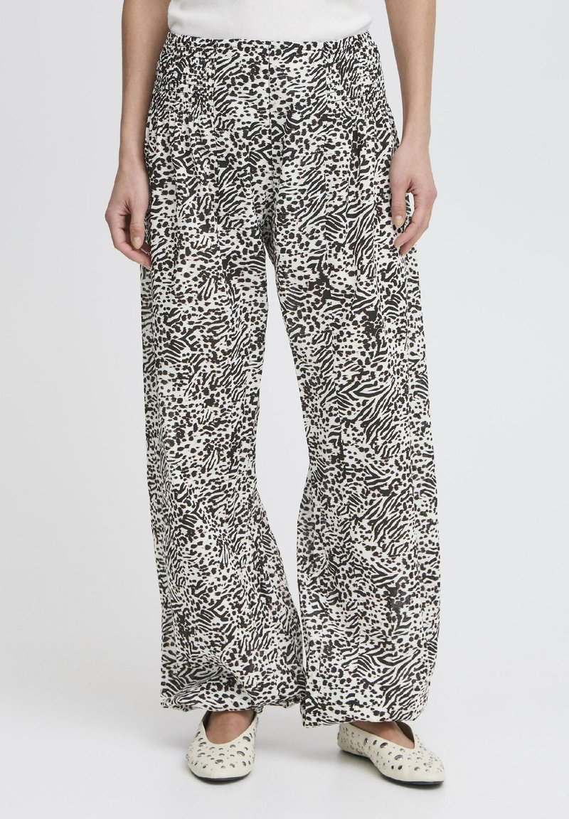 Pantalons légers et amples avec un motif abstrait noir et blanc. Ils présentent une taille élastique et une texture lisse.