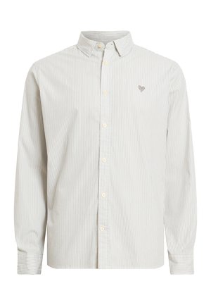 Camicia a righe con bottoni in beige chiaro e bianco. Presenta un colletto classico, maniche lunghe e un piccolo emblema ricamato sul petto.