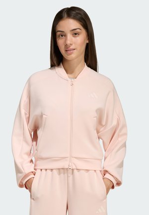 Hellrosa Reißverschlussjacke mit Stehkragen, langen Ärmeln und gerippten Bündchen; verfügt über Vordertaschen und ein kleines Logo auf der Brust.