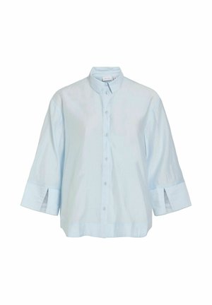 Blouse bleu clair à manches longues avec col mandarin, boutonnage sur le devant et larges poignets avec fentes sur le devant.