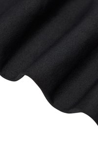 Zwarte stof met een zachte textuur, close-up weergegeven, zachtjes opgevouwen om gebogen golven en schaduwen te creëren.