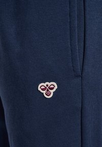 Jogging in blu navy realizzati in un morbido mix di cotone presentano un piccolo logo ricamato in bianco e bordeaux vicino alla cucitura della tasca.