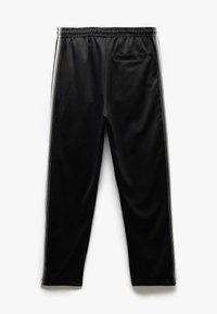 Pantalones deportivos negros con cintura elástica, franjas laterales en blanco, textura suave y un pequeño bolsillo trasero.