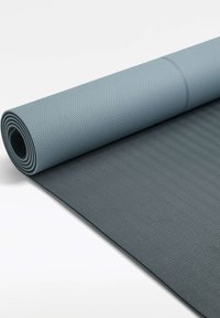 Siva joga podloga, delno razvaljana, teksturirana površina z diamantom vzorcem na vrhu in subtilnim valovitim vzorcem spodaj, fleksibilen material.