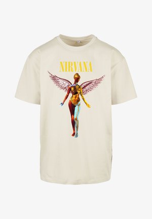 Cream-colored cotton t-shirt featuring a large graphic of a figure with anatomical details and wings, emblazoned with "NIRVANA" in bold yellow.
