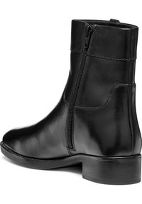 Bottines en cuir noir avec une fermeture éclair latérale, bout rond et un petit talon empilé. Texture lisse avec de subtils accents de couture.