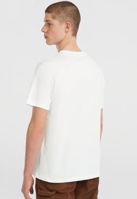 Hvid bomulds t-shirt med korte ærmer, rund halsudskæring og lige kant. Glat tekstur, minimalistisk design, ingen synlige logoer eller mønstre.